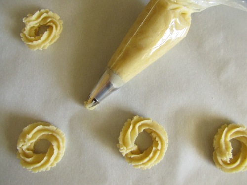 Making Vaniljekranse using a pastry bag with a star decorating tip. 